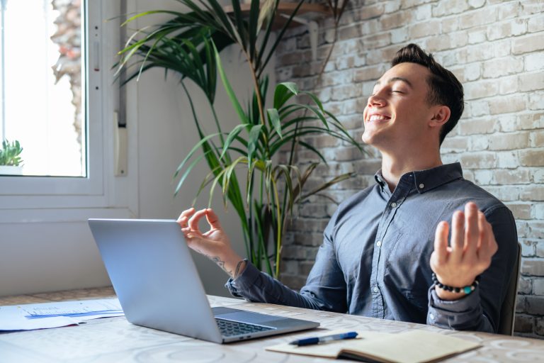 Serene office male employee sit at desk relaxing doing yoga, pra